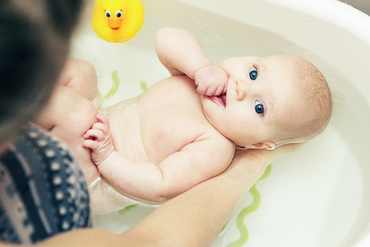 Bébé qui prend son bain avec sa maman.