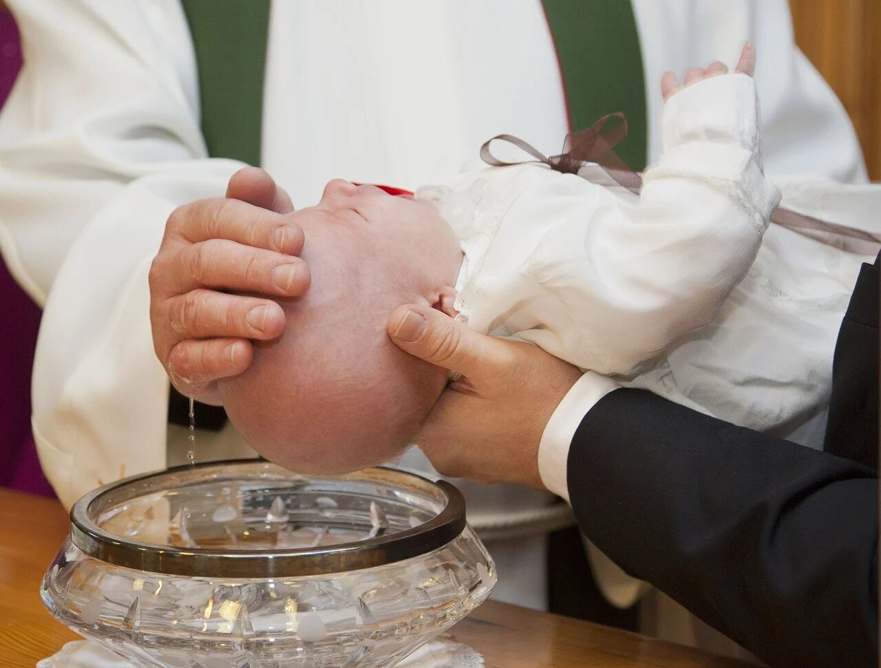 Lors d'un baptême, le bébé reçoit sa médaille de baptême.