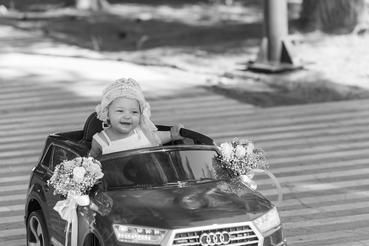 Cette voiture électrique pour bébé a des bouquets sur ses rétroviseurs.