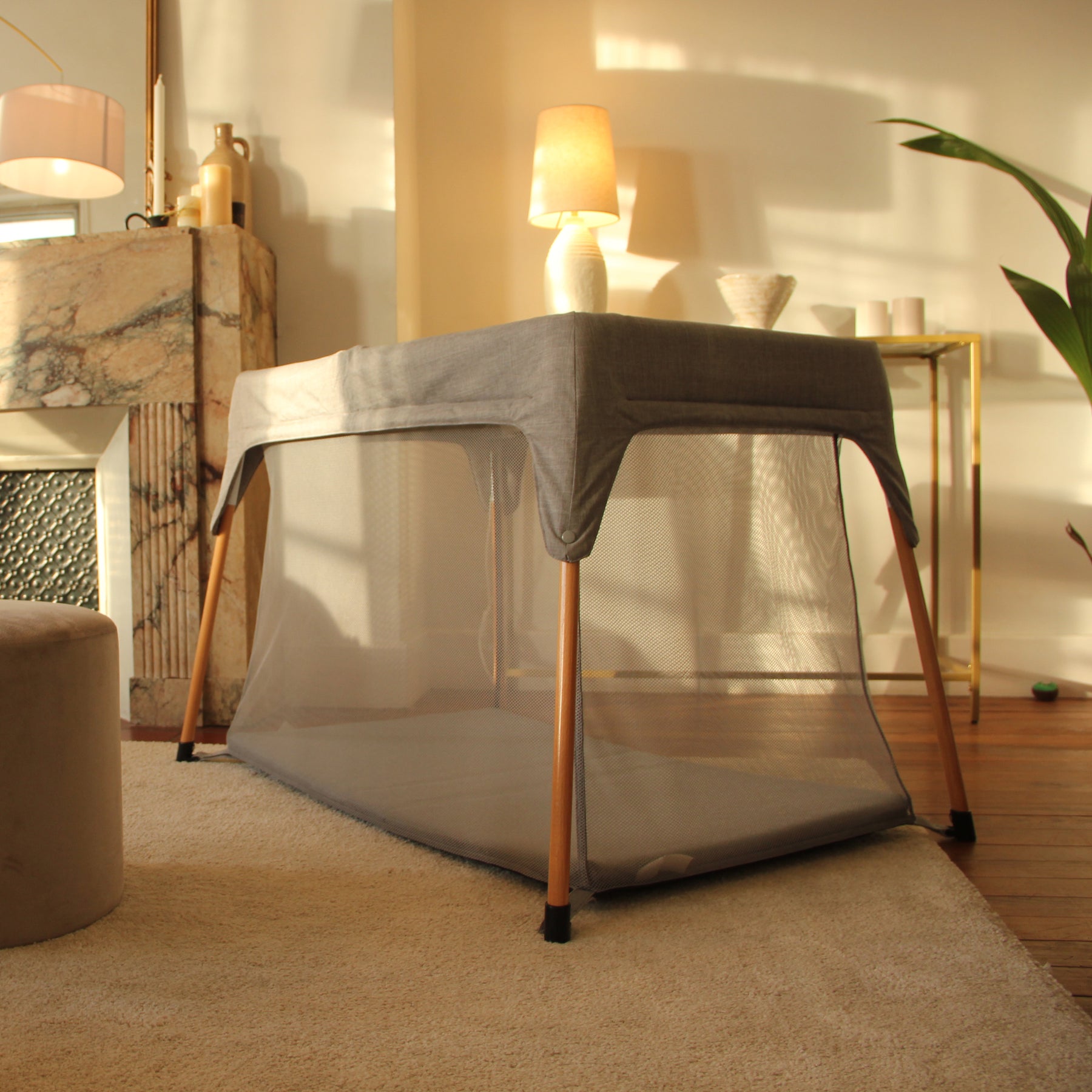 Ce lit parapluie bébé a des pieds en bois.