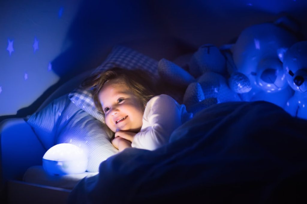 Cette petite fille admire une veilleuse pour bébé.