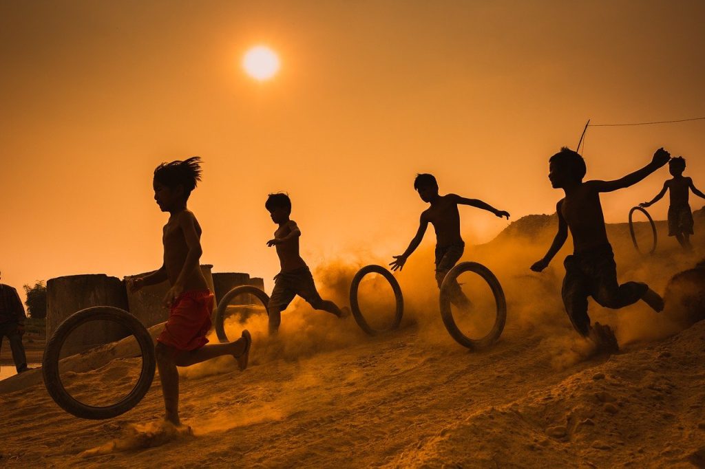 Ces enfants courent et jouent dehors avec des roues.