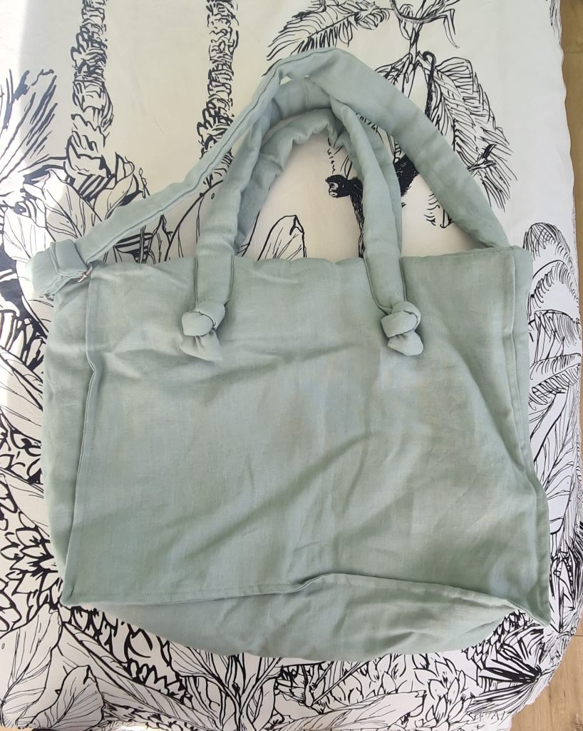 Ce sac à langer pour bébé en lin de la marque Petit Picotin est de couleur vert d'eau.