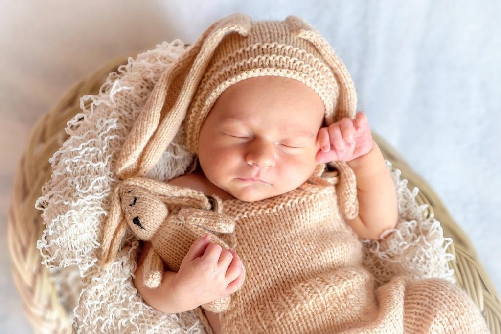 Ce bébé dort paisiblement avec son doudou.