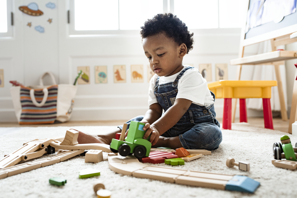 Cet enfant s'amuse avec ses jouets.