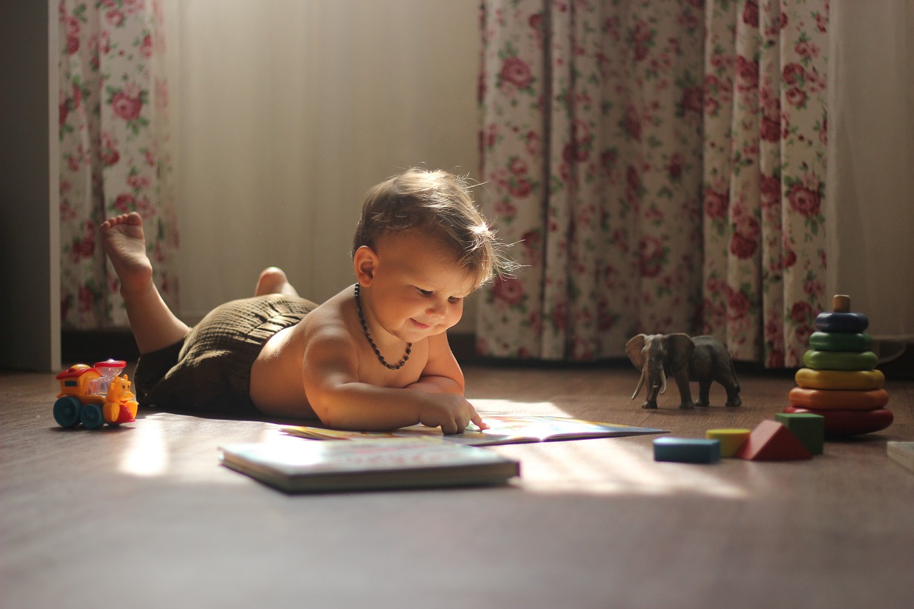 Cet enfant lit un magazine pour bébé.