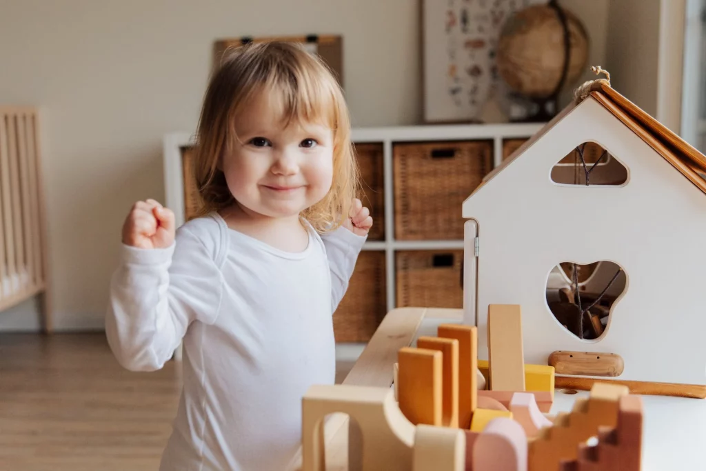 Cette petite fille s'amuse avec des jouets en bois.