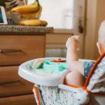 Ce bébé est dans une chaise haute.