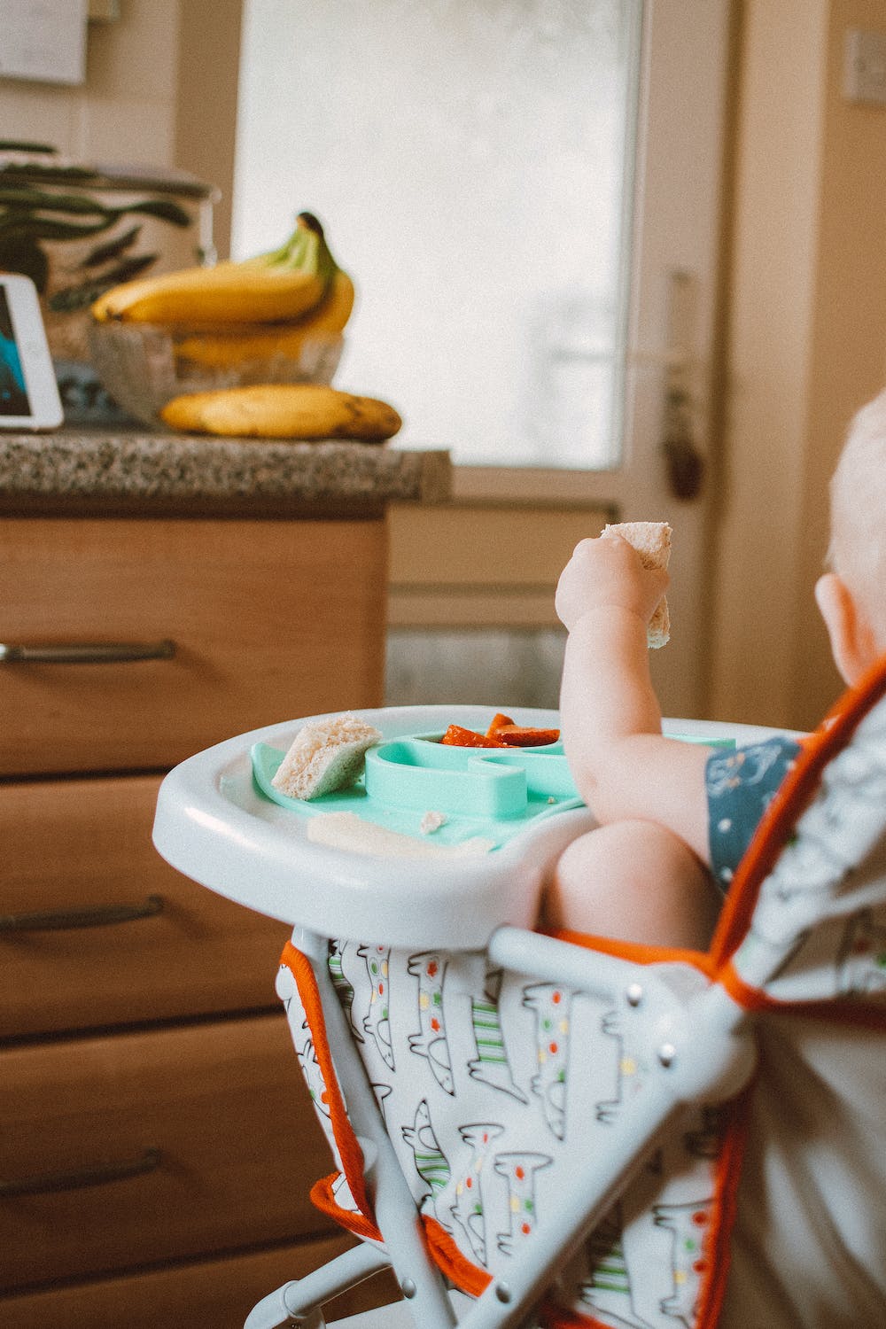 Ce bébé est dans une chaise haute.