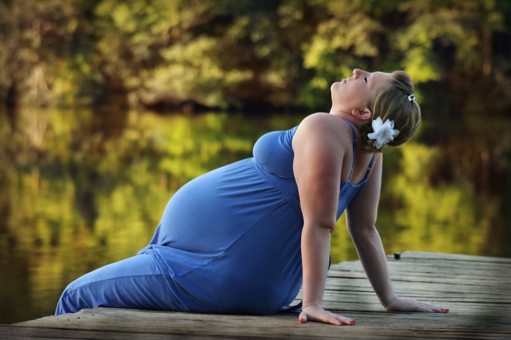 Cette maman porte une robe de grossesse bleue.