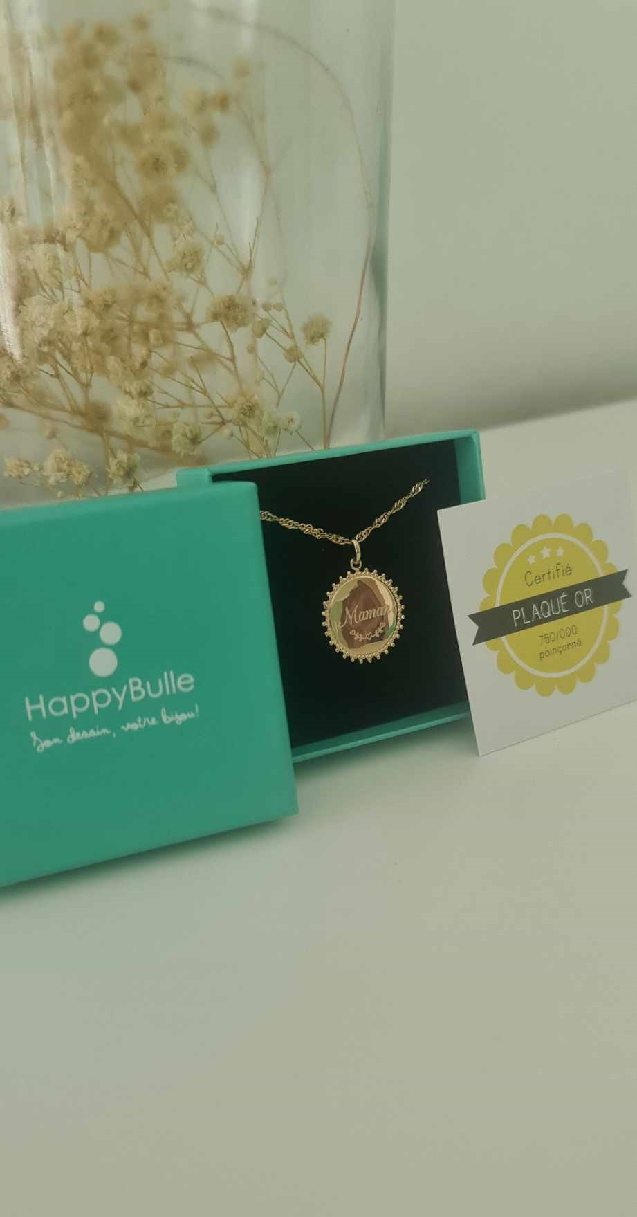 Ce bijou Happybulle est un collier personnalisé avec l'écriture "Maman" et un dessin en dessous.